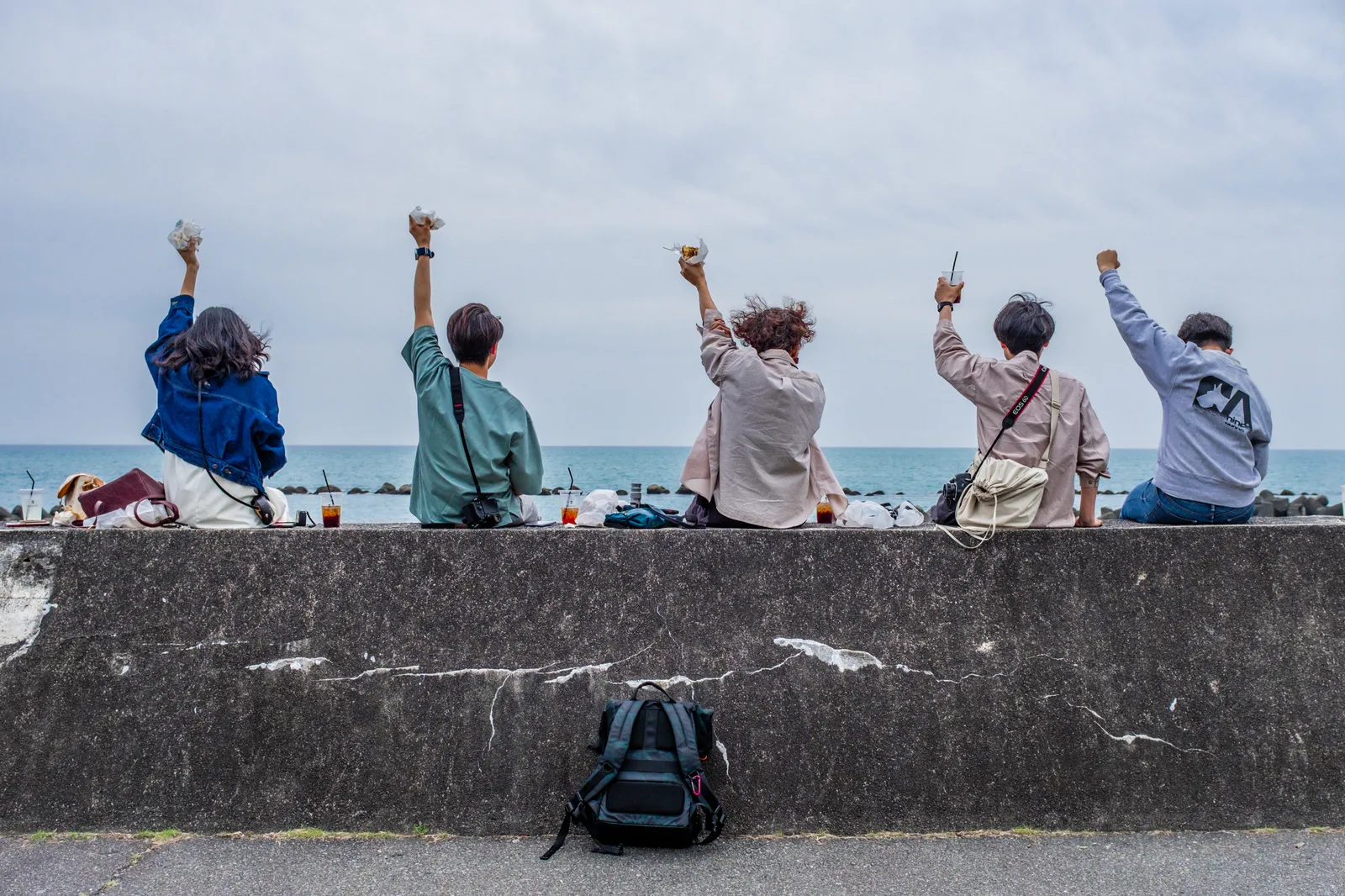 海辺で乾杯するメンバー